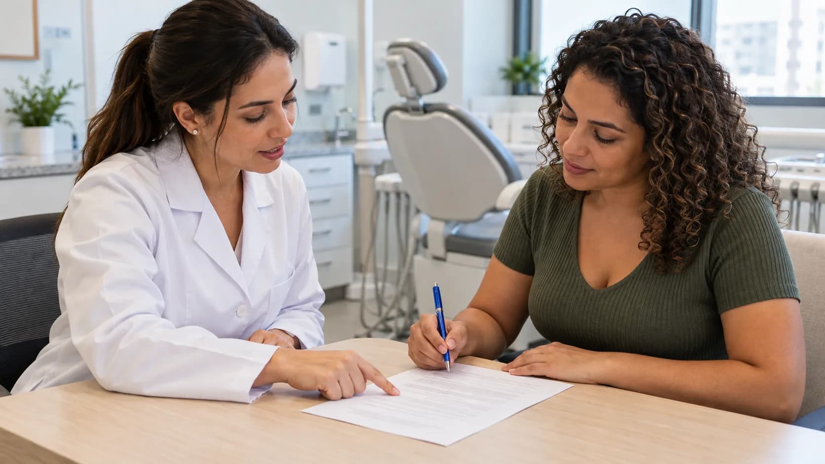 Dentista explica uma folha impressa a uma paciente adulta sentada à mesa do consultório, antes do atendimento, enquanto a paciente segura uma caneta.