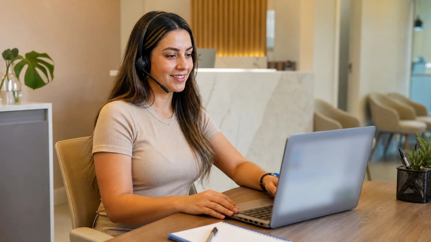Profissional de relacionamento faz contato por headset na área administrativa de uma clínica odontológica.